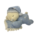 Orso della peluche che dorme sui cuscini blu